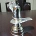 Parad Shivling weighing 300 grams having a flat base and a spherical top placed on a silver metal yoni and a silver metal revolvable serpant.
